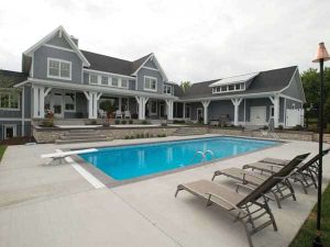 An apartment complex clubhouse with a pool and chairs