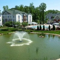 A fountain and swimming pool outside of a Donaldson apartment community