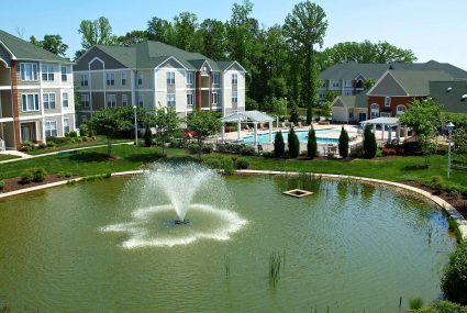A fountain and swimming pool outside of a Donaldson apartment community
