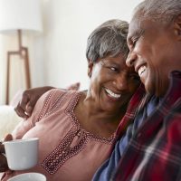 A man and woman on a sofa enjoying coffee
