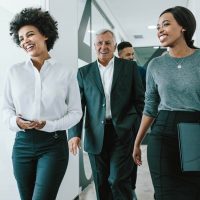 A group of professionals in business attire walking in a hallway